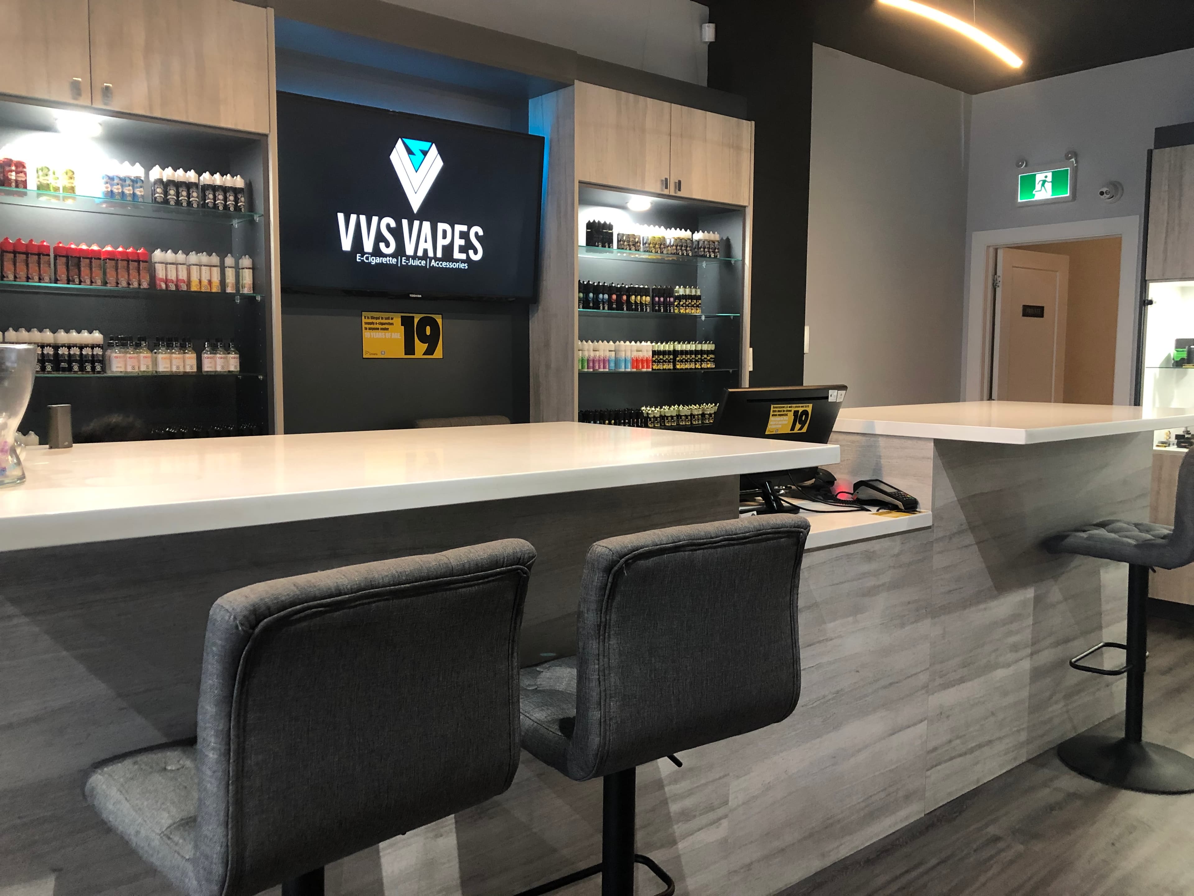 VVS Vapes service bar with illuminated shelves and brand screen