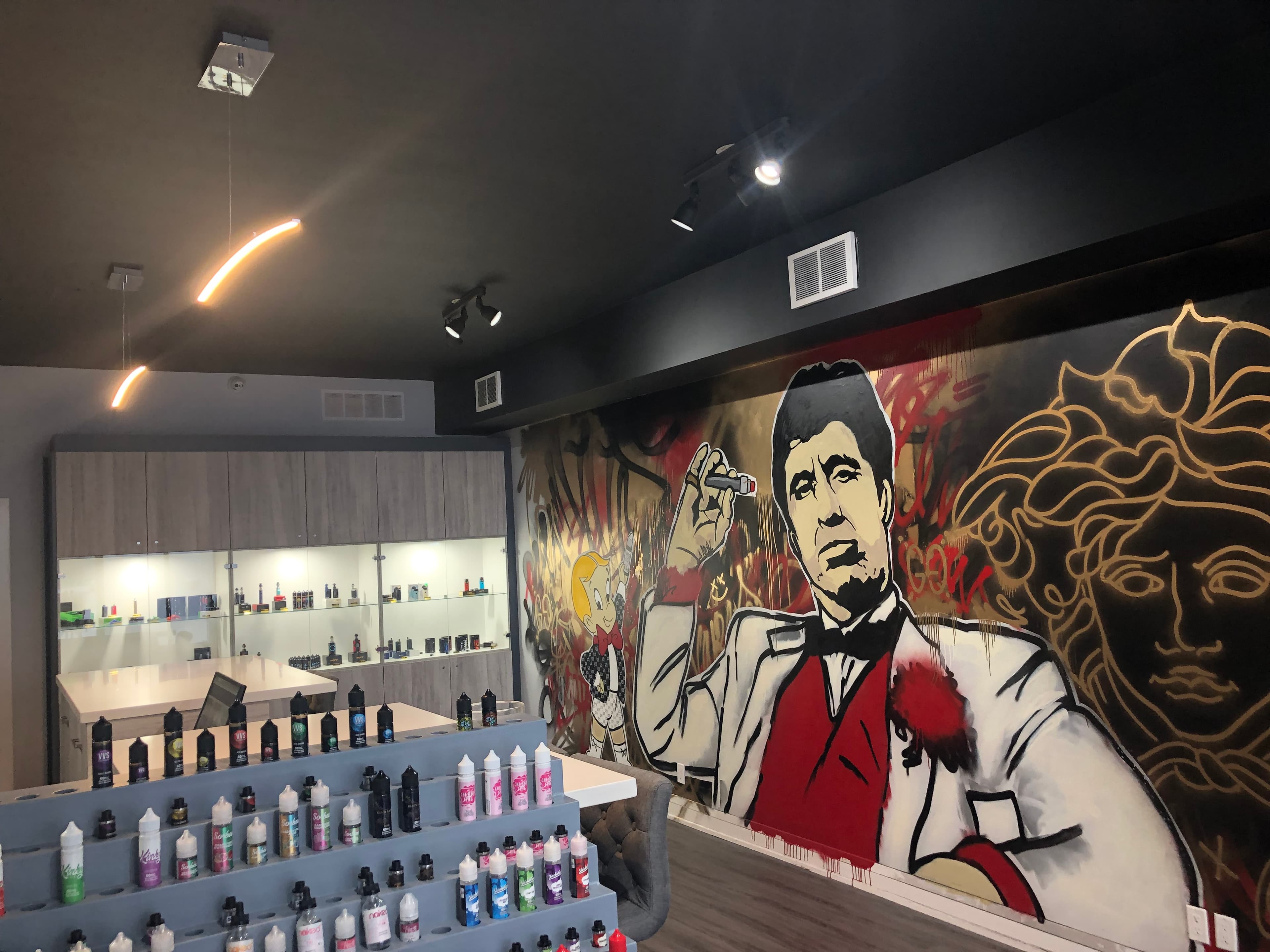 Street-art mural wall inside VVS Vapes with e-liquid displays